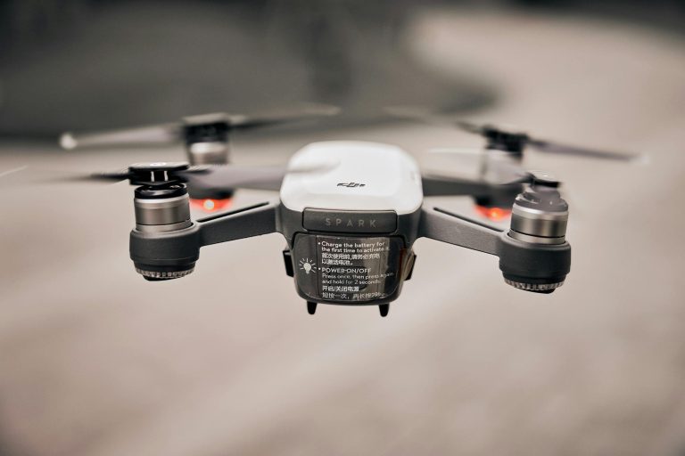 Close-up of a modern drone flying outdoors, showcasing advanced technology and propellers.